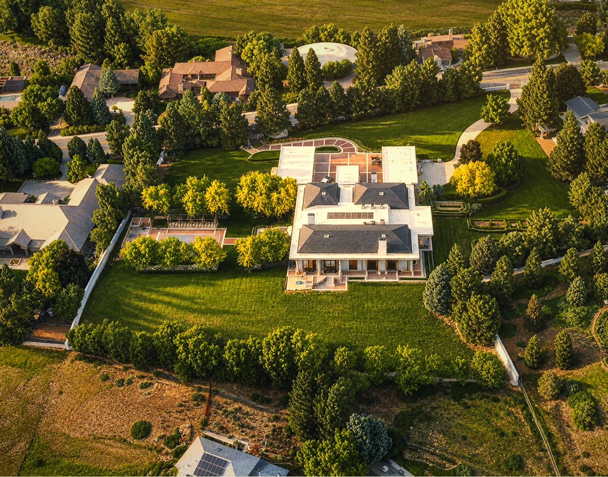 Golden-hour aerial of the walled estate against the Boise foothills